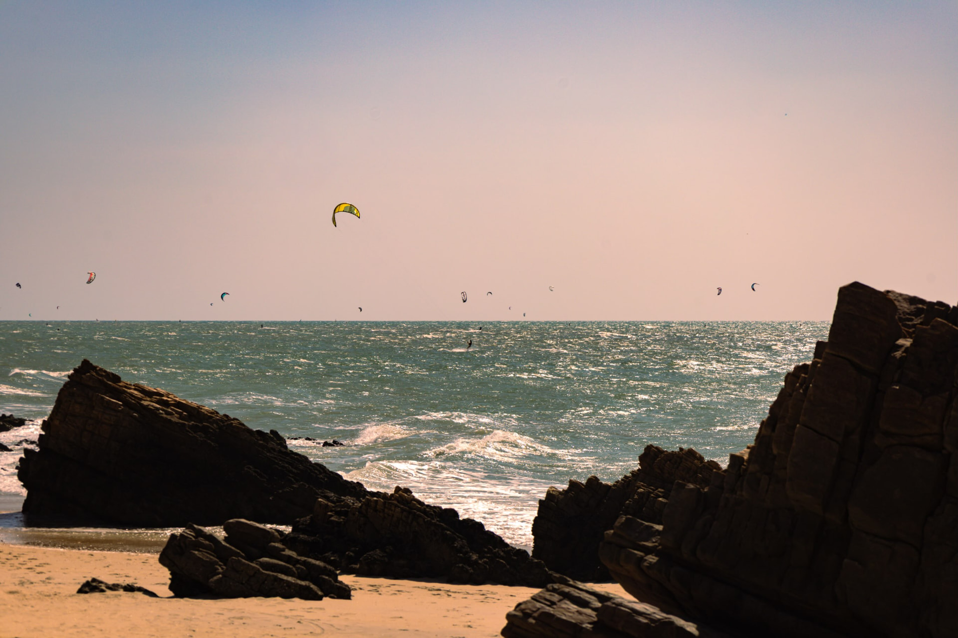 Kitesurfistas entre as formações rochosas e o mar de Jericoacoara